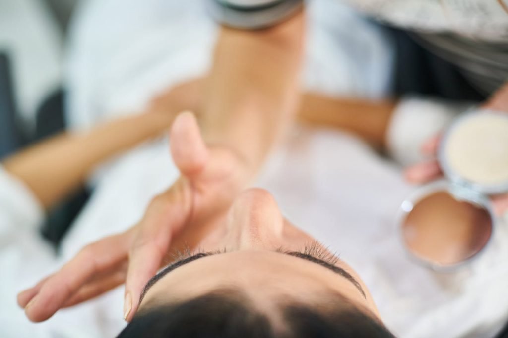 person-touching-woman-s-face-3148935 Close-up view of a professional makeup artist applying cosmetics indoors, highlighting beauty and skin care.